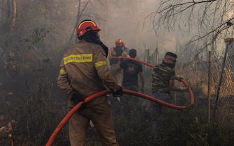 (230721) -- ATHENS, July 21, 2023 (Xinhua) -- Firefighters and volunteers put out a wildfire in Agia Sotira, a western suburb of Athens, Greece, on July 20, 2023. For the fourth consecutive day, the wildfires continue to ravage houses and forests in the western part of Athens. (Photo by Lefteris Partsalis/Xinhua) - Lefteris Partsalis -//CHINENOUVELLE_CHINENOUVELLE0139/Credit:CHINE NOUVELLE/SIPA/2307221126