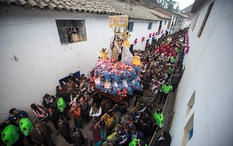 FILED - 15 July 2018, Peru, Paucartambo: An effigy of the Virgin 'Carmen' is carried through the village, while residents film the procession with smartphones from the window. The festival lasts several days. On the last day the parade moves to the cemetery, where all participants honour deceased dancers. Photo: CÃ©sar Campos/dpa (Photo by CÃ©sar Campos/picture alliance via Getty Images)