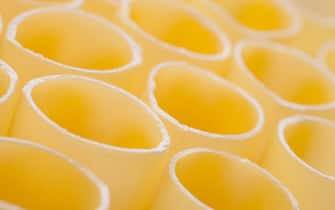 dried cannelloni background or yellow pasta texture
