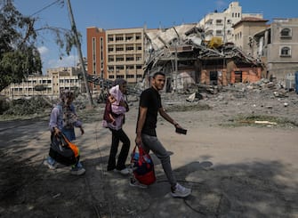 epa10911567 A Palestinian family carry their belongings in the destroyed Al-Ramal neighborhood following an Israeli air strike in Gaza City, 10 October 2023. More than 700 people have been killed and around 4,000 have been injured according to the Palestinian Ministry of Health, after Israel started bombing the Palestinian enclave in response to an attack carried out by the Islamist movement Hamas on 07 October. More than 3,000 people, including 1,500 militants from Hamas, have been killed and thousands injured in Gaza and Israel since 07 October, according to Israeli military sources and Palestinian officials.  EPA/MOHAMMED SABER