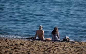 BARCELONA, CATALONIA, SPAIN - 2022/12/25: A couple enjoys Christmas day on the seashore at Playa de la Barceloneta. Unusual temperatures in Catalonia (Spain) that is forecast as Christmas Day with the warmest temperature of the century with highs of 23 and 24 º. (Photo by Paco Freire/SOPA Images/LightRocket via Getty Images)