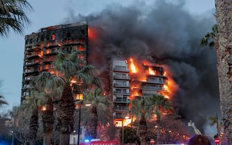 epa11173272 Smoke rises from a fire of a 14-story residential building in Valencia, eastern Spain, 22 February 2024. At least seven people were injured during the ongoing fire, and two people trapped on a balcony were rescued by firefighters.  EPA/MANUEL BRUQUE