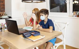 Kids studying at home during quarantine period for prevention of coronavirus or covid-19 outbreak. Home school or remote learning with parents helping children study at home for coping virus spreading