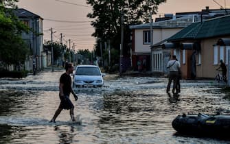 epa10676369 People walk in a flooded street of Kherson, Ukraine, 06 June 2023.Ukraine has accused Russian forces of destroying a critical dam and hydroelectric power plant on the Dnipro River in the Kherson region along the front line in southern Ukraine on 06 June. A number of settlements were completely or partially flooded, Kherson region governor Oleksandr Prokudin said on telegram. Russian troops entered Ukraine on 24 February 2022 starting a conflict that has provoked destruction and a humanitarian crisis.  EPA/IVAN ANTYPENKO