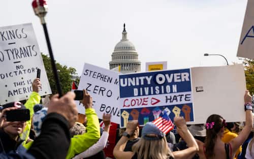 epa12462536 People gather on Pennsylvania Avenue, with the US Capitol in the background, to participate in the 'No Kings' protest in Washington, DC, USA, 18 October 2025. The protest is part of a nationwide 'No Kings' day of action, opposing what organizers see as authoritarian overreach and threats to democracy under US President Trump.  EPA/LUKE JOHNSON