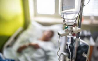 Drip infusion of a patient in a hospital room.