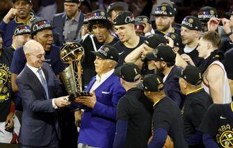 epa10687810 NBA Commissioner Adam Silver (L) presents the NBA Championship trophy to Denver Nuggets owner Stan Kroenke (2-L) while surrounded by members of the Nuggets team following their win in game five of the NBA Finals over the Miami Heat at Ball Arena in Denver, Colorado, USA, 12 June 2023.  EPA/JOHN G. MABANGLO  SHUTTERSTOCK OUT