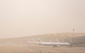 BEIJING, CHINA - MARCH 22: Planes are seen at Beijing Capital International Airport during a sandstorm on March 22, 2023 in Beijing, China. (Photo by VCG/VCG via Getty Images)