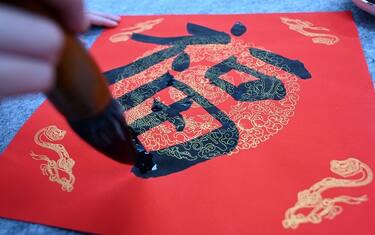 NEIJIANG, CHINA - JANUARY 12: A student writes Chinese character 'Fu', meaning 'good luck', to welcome the Chinese Lunar New Year, the Year of the Rabbit, on January 12, 2023 in Neijiang, Sichuan Province of China. (Photo by Lan Zitao/VCG via Getty Images)