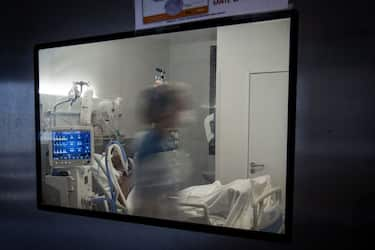 TOPSHOT - Medical staff members tend to a Covid-19 patient under respiratory assistance, in a room of the intensive care unit of the Pierre Zobda-Quitman University hospital (CHU) in Fort-de-France on the French Caribbean island of Martinique, on December 1, 2021. - Unrest in the neighbouring island and former colonial outpost of Guadeloupe began with a protest over compulsory Covid-19 vaccinations for health workers, but quickly ballooned into a broader revolt over living conditions, and spread to next door Martinique. (Photo by ALAIN JOCARD / AFP) (Photo by ALAIN JOCARD/AFP via Getty Images)