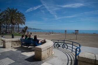 MALAGA, SPAIN - 2023/03/12: People are seen sitting on a bench at the promenade as they sunbathe near the beach during a hot spring day. The good weather and high temperatures have made the beaches along the Andalusian coast full. The Spanish state meteorology agency warned of an unusual episode of high temperatures over the next few days, with temperatures that could reach over 30 degrees. (Photo by Jesus Merida/SOPA Images/LightRocket via Getty Images)