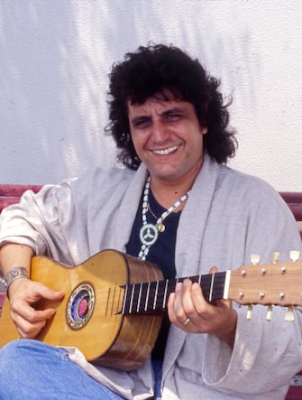 The Italian singer-songwriter Pino Daniele plays the guitar sitting on a bench. Italy, July 26th, 1987 (Photo by Barbara Rombi Serra /Mondadori Portfolio via Getty Images)