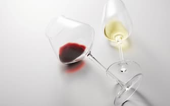 Little red, white wine is poured into stem glasses.