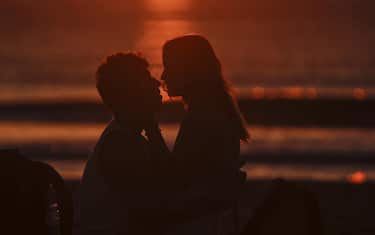 epa10031356 A couple kiss at sunrise the morning after the Saint John's Eve celebrations at Malvarrosa beach in Valencia, Spain, 24 June 2022. Saint John's Eve marks the shortest night of the year.  EPA/Manuel Bruque