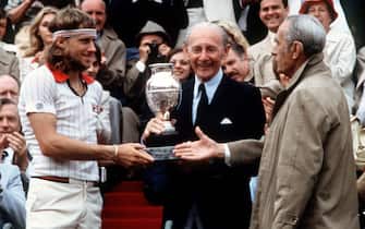 Sweden's tennis player Bjorn Borg (left) receives the Winner's Trophy from former tennis "musketeers" Jean Borotra (center) and Henri Cochet (right) here 09 june 1979 after defeating Italian Victor Pecci during the Men's French Open Finals at Roland Garros stadium. (Photo by AFP) (Photo by -/AFP via Getty Images)