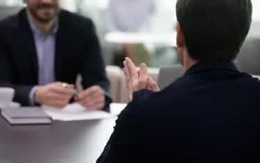 Back view applicant communicating with HR manager passing job interview