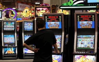 Un uomo gioca con una slot machine in una foto d'archivio. ANSA / YM YIK  .