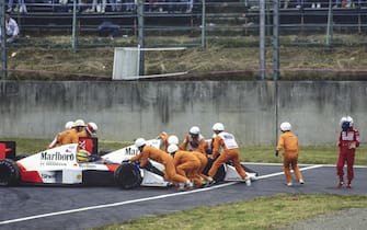 SUZUKA, JAPAN - OCTOBER 22: Alain Prost walks away, as marshals recover his car and push Ayrton Senna, McLaren MP4-5 Honda, in order for him to rejoin during the Japanese GP at Suzuka on October 22, 1989 in Suzuka, Japan. (Photo by Steven Tee / LAT Images)