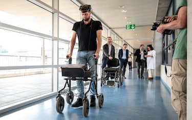 Gert-Jan from the Netherlands, (who did not wish to give his surname), 40, victim of a spinal cord injury that left him paralyzed, walks with his implants during a press conference in Lausanne on May 23, 2023. For the first time after more than a decade of work by researchers in France and Switzerland, a paralysed man has regained the ability to walk naturally using only his thoughts thanks to two implants that restored communication between his brain and spinal cord. The advance was revealed in a study in the journal Nature. (Photo by Fabrice COFFRINI / AFP) (Photo by FABRICE COFFRINI/AFP via Getty Images)