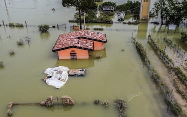 An aerial view taken on May 18, 2023 shows a flooded house in the town of Cesena, after heavy rains caused flooding across Italy's northern Emilia Romagna region, killing five people. (Photo by Alessandro SERRANO / AFP)