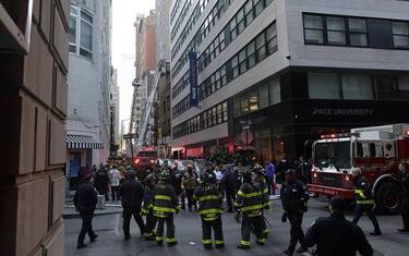 epa10579297 New York City Fire Department firefighters work on ladder trucks at the scene of a parking structure collapse in the Financial District of New York City, New York, USA, 18 April 2023. Fire Department officials have reported three injuries but advised they expect that to increase.  EPA/JUSTIN LANE