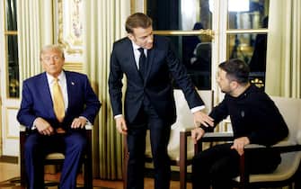 France's President Emmanuel Macron (C), US president-elect Donald Trump (L) and Ukraine's President Volodymyr Zelensky pose before a meeting at The Elysee Presidential Palace in Paris on December 7, 2024. Trump makes his first international trip since his election win, preparing for a day of intense diplomacy before attending the reopening ceremony for the Notre Dame cathedral restored after the 2019 fire. (Photo by Sarah Meyssonnier / POOL / AFP)