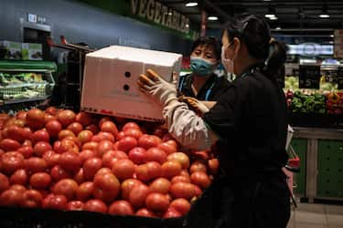epa09191028 Saleswomen unload tomatoes in a supermarket in Beijing, China, 11 May 2021. According to the National Bureau of Statistics, China's Consumer Price Index (CPI), which is a main gauge of inflation, rose 0.9 percent year-on-year in April 2021.  EPA/WU HONG