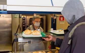 ROME, ITALY - MARCH 18: A volunteer nun wearing a face mask serves the meal to a homeless at the canteen of Caritas Colle Oppio, the canteen serves 400 meals a day, during the Coronavirus emergency on March 18, 2020, in Rome, Italy. In Rome there are between 14-16 thousand homeless citizens and to contain the coronavirus emergency, it is not possible for those who do not have a home. The Italian Government has taken the unprecedented measure of a nationwide lockdown by closing all businesses except essential services such as, pharmacies, grocery stores, hardware stores and tobacconists and banks, in an effort to fight the world's second-most deadly coronavirus (COVID-19) outbreak outside of China. The movements in and out are allowed only for work and health reasons proven by a medical certificate. The number of confirmed cases of the COVID-19 disease in Italy has jumped up to at least 28710 while the death toll has reached 2978. (Photo by Stefano Montesi - Corbis/ Getty Images)