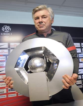 Paris Saint-Germain coach Carlo Ancelotti poses with the Ligue 1 trophy after holding a press conference at Camp des Loges PSG training center in Saint-Germain en Laye, near Paris, France, 17 May 2013.  
ANSA/YOAN VALAT