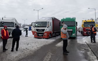 Ukrainian truck drivers are seen next to Ukrainian trucks on the parking lot near Korczowa Polish-Ukrainian border crossing, on December 5, 2023. In a Polish car park near the Ukrainian border, truck drivers stranded by a month-long blockade that has caused disruption and a row with Ukraine shoveled snow off their vehicles.
Around 100 truckers have been stuck in Korczowa, one of the crossings blocked by protesting Polish hauliers who complain about what they say is unfair competition from Ukrainian companies. (Photo by Wojtek Radwanski / AFP) (Photo by WOJTEK RADWANSKI/AFP via Getty Images)