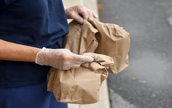 Muhlenberg twp., PA - September 10: A school district employee holds bags containing breakfasts and a lunchs, to distribute. At the Muhlenberg Elementary Center in Muhlenberg twp, PA Thursday morning September 10, 2020 where school district employees were distributing grab and go meals to students. The program has been going on since the start of the COVID-19 pandemic and is continuing this school year as all education in the district is being done virtually. (Photo by Ben Hasty/MediaNews Group/Reading Eagle via Getty Images)