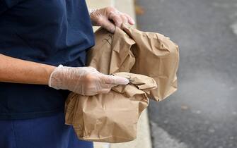 Muhlenberg twp., PA - September 10: A school district employee holds bags containing breakfasts and a lunchs, to distribute. At the Muhlenberg Elementary Center in Muhlenberg twp, PA Thursday morning September 10, 2020 where school district employees were distributing grab and go meals to students. The program has been going on since the start of the COVID-19 pandemic and is continuing this school year as all education in the district is being done virtually. (Photo by Ben Hasty/MediaNews Group/Reading Eagle via Getty Images)