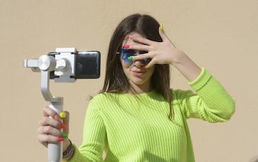 Young woman influencer take a selfie with smartphone outdoors