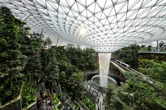 SINGAPORE - APRIL 11:  The skytrain rides past the Rain Vortex at the Jewel Changi Airport on April 11, 2019 in Singapore. Officially opening on April 17, Singapore's Changi Airport Jewel includes a 40-meter indoor waterfall contained under a steel-and-glass dome reportedly built for SGD 1.7 billion. (Photo by Suhaimi Abdullah/Getty Images)