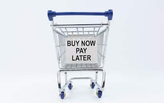 Business concept. On a white background is a shopping cart with a sign that says - Buy Now Pay Later