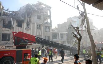 epa12172797 Fire fighters, rescue workers and security personnel work around a building that was hit by Israeli air strikes in central Tehran, Iran, 13 June 2025. Israel confirms it has launched strikes on Iran's 'nuclear program' as blasts are heard across the country. The strikes are part of Operation Rising Lion, Israel's Prime Minister Benjamin Netanyahu said, adding Iran was a threat to "Israel's very survival".  EPA/ABEDIN TAHERKENAREH