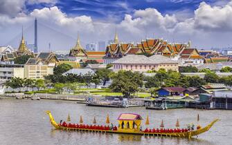 Landscape of Thai's king palace with goldent guard ship on the front.