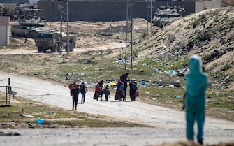 epa11198260 Israeli tanks on patrol (background) as internally displaced Palestinians walk after the Israeli army told residents of the Hamad area in Khan Yunis to leave their homes and head towards Rafah, near the border with Egypt, southern Gaza Strip, 04 March 2024. The Israeli military stated on 04 March that a humanitarian evacuation corridor was established to allow civilians to exit the area. More than 30,500 Palestinians and over 1,300 Israelis have been killed, according to the Palestinian Health Ministry and the Israel Defense Forces (IDF), since Hamas militants launched an attack against Israel from the Gaza Strip on 07 October 2023, and the Israeli operations in Gaza and the West Bank which followed it.  EPA/MOHAMMED SABER