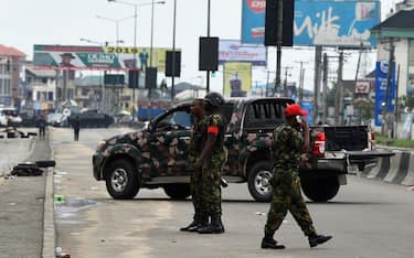 Soldiers block with truck and armoured tank the road leading to the state headquarters of Independent National Electoral Commission (INEC) in Port Harcourt, Rivers State, on March 10, 2019. - Fears has gripped residents of oil-rich Port Harcourt city in Niger delta region as state headquarters of Independent National Electoral Commission has been condoned off by dozens of fierce looking soldiers, anti-riots policemen and other complementary security agents who are jointly patrolling the city ahead of the much awaited results of the just concluded governorship and state assembly elections. (Photo by PIUS UTOMI EKPEI / AFP)        (Photo credit should read PIUS UTOMI EKPEI/AFP via Getty Images)