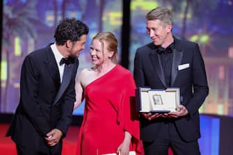 CANNES, FRANCE - MAY 27: Alma Poysti (C) and Jussi Vatanen (R) receive The Jury Prize Award for 'Fallen Leaves' from Orlando Bloom (L) during the closing ceremony during the 76th annual Cannes film festival at Palais des Festivals on May 27, 2023 in Cannes, France. (Photo by Andreas Rentz/Getty Images)