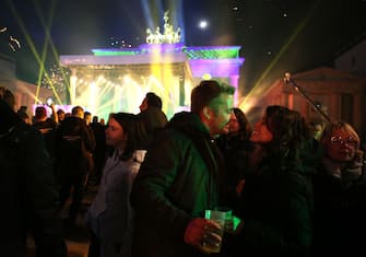 BERLIN, GERMANY - JANUARY 01: Visitors celebrate the new year at the Brandenburg Gate on January 01, 2023 in Berlin, Germany. For the past two years amidst the Coronavirus (COVID-19) pandemic, there was a national ban on purchasing and setting off fireworks in the country in order to avoid the gathering of crowds thwarting social distancing policies as well as to prevent the overburdening of hospitals. While the ban has been lifted to allow sales and use of fireworks over a period of three days, no official fireworks show as per the annual tradition was held at the Brandenburg Gate. (Photo by Adam Berry/Getty Images)