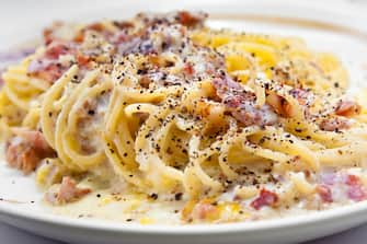 Spaghetti, bacon, white sauce, black pepper.