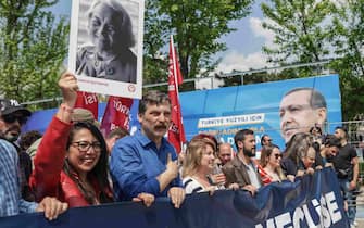 epa10601912 Erkan Bas(2-R), leader of Worker's Party of Turkey and Sera Kadigil (L), deputy of Worker's Party of Turkey walk in front of a picture of Turkish President Recep Tayyip Erdogan during a May Day celebration rally in Istanbul, Turkey, 01 May 2023. International Workers' Day is an annual holiday that takes place on 01 May and celebrates workers, their rights, achievements and contributions to society.  EPA/ERDEM SAHIN