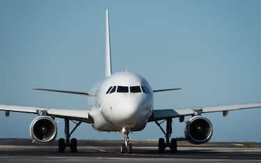 White plane to runway for take off, airplane taxiing for take off. White passenger jet plane taxiing along the runway in the airport