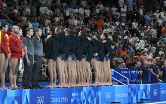 Italy's team players turn their back during the anthem to protest against the refereeing of their last match against Hungary, before the men's water polo 5th-8th classification match between Italy and Spain at Paris 2024 Olympic Games at the Paris La Defense Arena in Paris on August 9, 2024. (Photo by Andreas SOLARO / AFP)