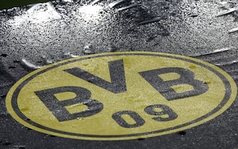 The logo of BVB Borussia Dortmund is seen on the ground covered in rain drops during a training session on the eve of the UEFA Champions League football match between BVB Borussia Dortmund and Paris St Germain in Dortmund, western Germany, on December 12, 2023. (Photo by FRANCK FIFE / AFP) (Photo by FRANCK FIFE/AFP via Getty Images)