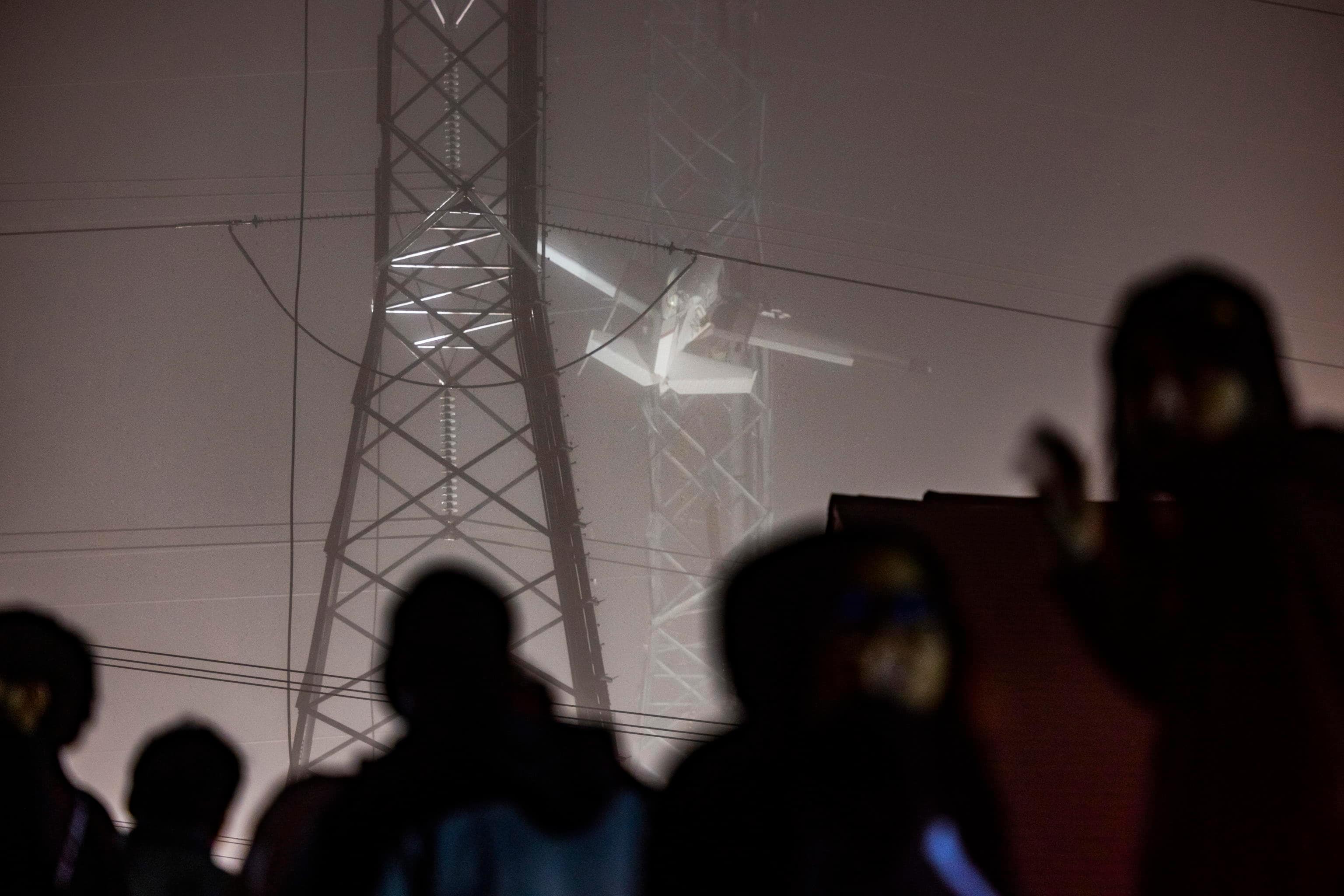 epa10333584 People watch a small plane that crashed into a power line, knocking out electricity for tens of thousands of residents, in Gaithersburg, Maryland, USA, 28 November 2022.  EPA/JIM LO SCALZO