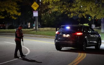 epa10939763 A police officer stands guard on a street leading to the bowling alley where a man reportedly opened fire killing and injuring numerous people in Lewiston, Maine, USA, 25 October 2023. Early reports indicate as many as 20 people have been killed, and dozens injured. Police are still searching for the suspect.  EPA/CJ GUNTHER