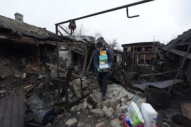 Residents and neighbors carry belongings out of a destroyed house hit by recent shelling in Donetsk, Russian-controlled Ukraine, on December 19, 2023, amid the Russia-Ukraine conflict. (Photo by STRINGER / AFP) (Photo by STRINGER/AFP via Getty Images)
