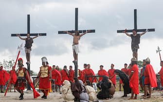 epa11249104 Filipino Ruben Enaje (C), who portrays Jesus Christ, is nailed to a wooden cross during a re-enactment of the crucifixion of Jesus Christ to mark Good Friday in San Fernando City, Pampanga province, Philippines, 29 March 2024. The 63-year-old Enaje is on his 35th year of portraying Jesus Christ in the passion play. While the Catholic church and government health officials have for years urged devotees to refrain from self-inflicted pain during the Lent season, practices of flagellation and painful depictions of the suffering of Jesus Christ to express faith and penance have become traditions that are hard to break in Catholic communities all over the country.  EPA/ROLEX DELA PENA